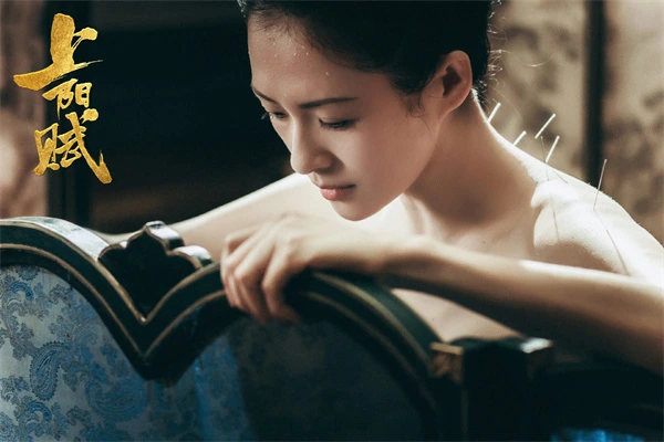 Woman with acupuncture needles in "A Feminilidade" shows resilience.