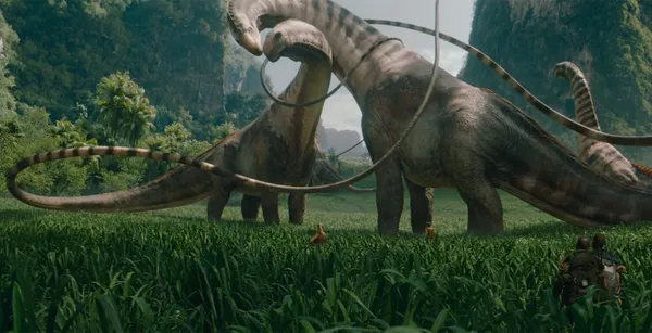 Gigantic sauropods in "Jurassic World Rebirth" towering over characters in a grassy field.