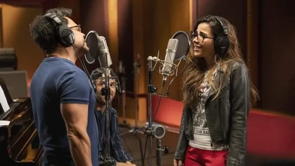 Man and woman sing in a recording studio in The Family That Sings Together: The Camargos.