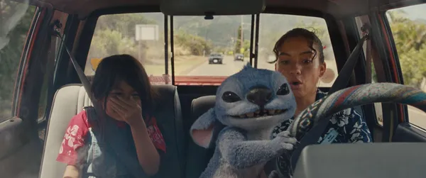 Stitch holds the steering wheel in a car in "Lilo & Stitch (2025)".