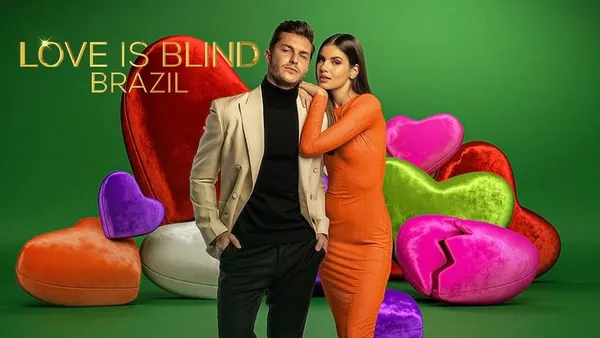 A couple from "Love Is Blind Brazil" poses amid colorful heart decorations.